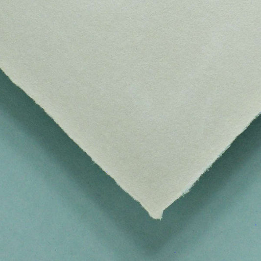 Büttenpapier Detail Ecke vor grünem Hintergrund, sandfarben