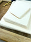 dekoratives Arrangement von cremefarbenem Büttenpapier mit Schreibfeder 